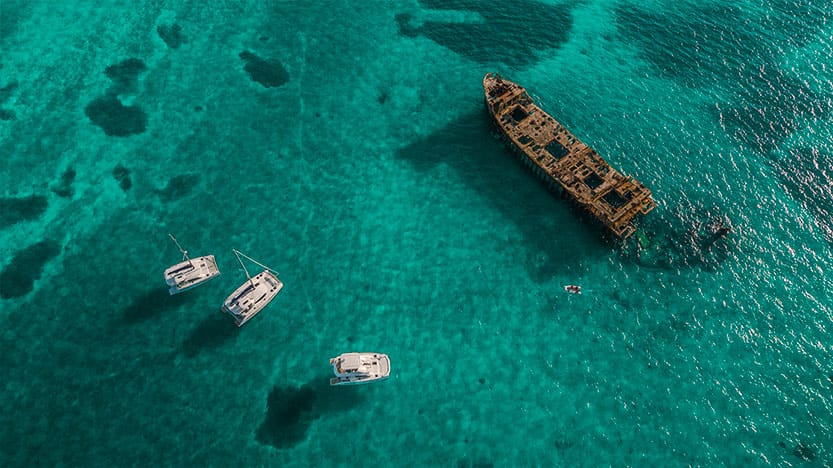 Luftaufnahme dreier Leopard Catamarans Katamarane auf türkisblauem Karibik-Wasser