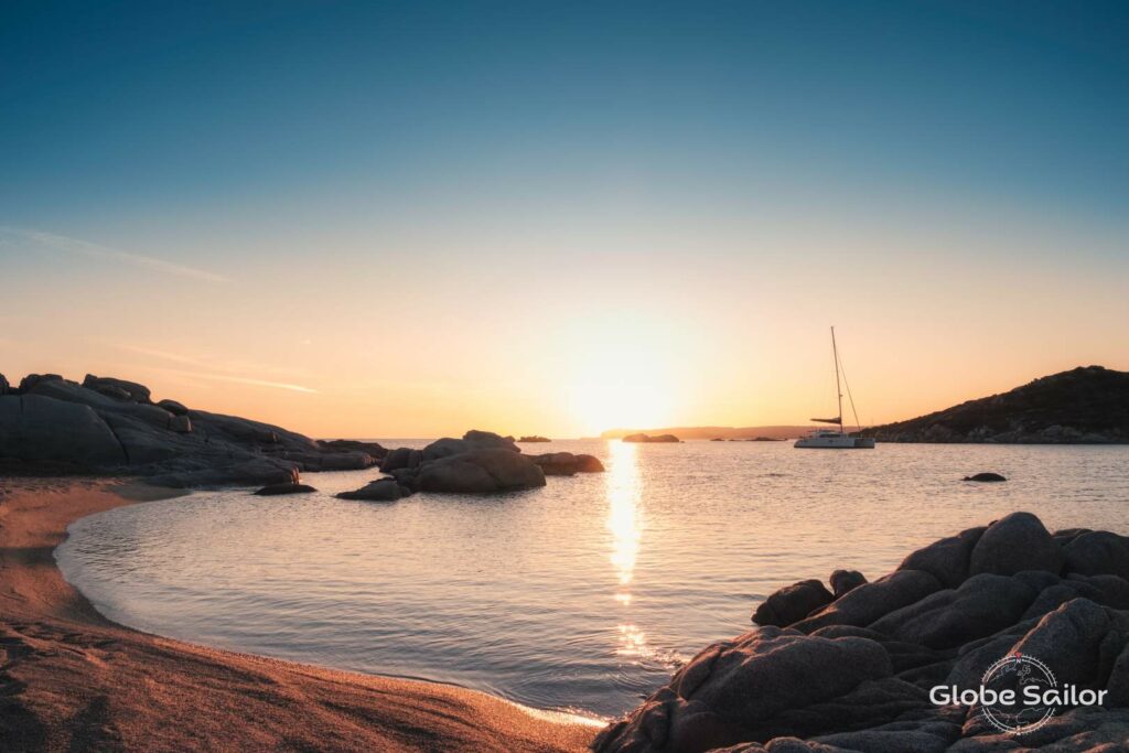 Foto eines bei Sonnenuntergang ankernden Bootes: Die Vorschriften für das Segeln und Yachtchartern in Italien schützen die Natur und erhalten ein Traum-Segelrevier.