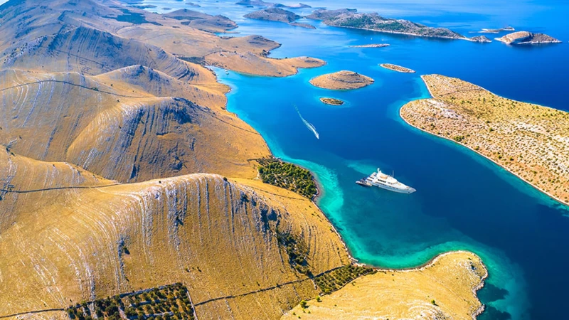 Inseln & türkisfarbene Buchten (Luftaufnahme)
Spektakuläre Luftaufnahme der kroatischen Inselwelt mit türkisfarbenem Meer, einsamen Buchten und einer Luxusyacht – traumhafte Kulisse für Segelurlaub, Inselhopping und exklusive Yachtcharter in der Adria.