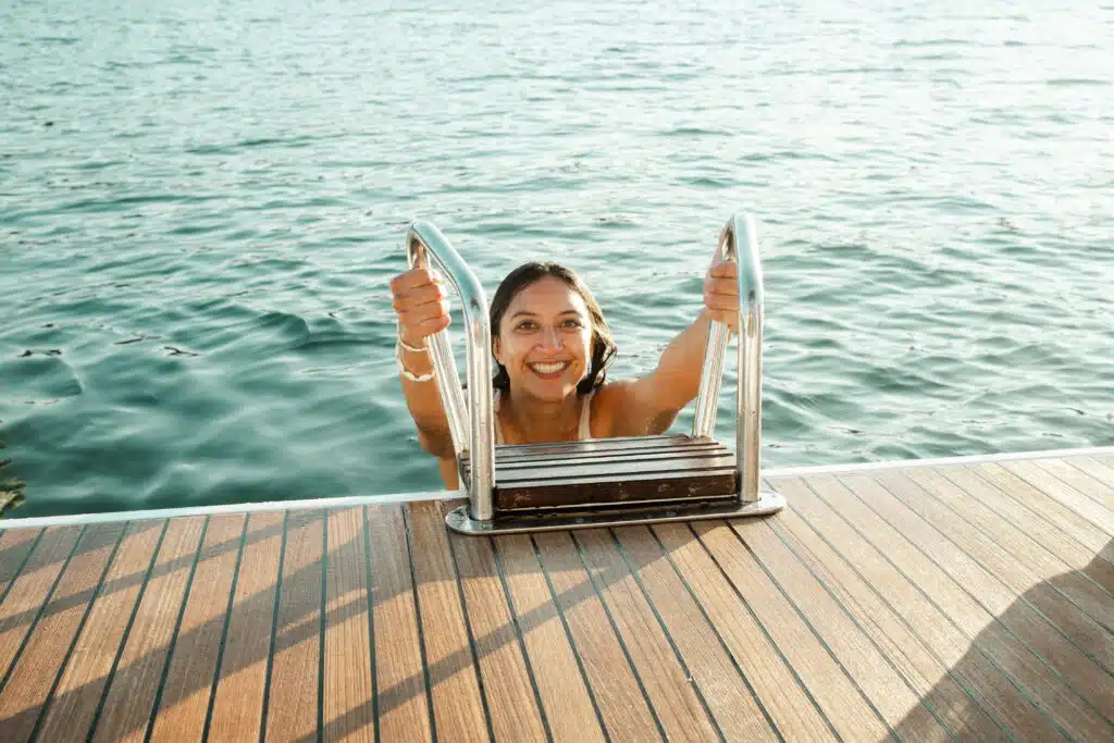 Seglerin steigt vom Boot ins Meer – Badepause beim Segelurlaub in Griechenland