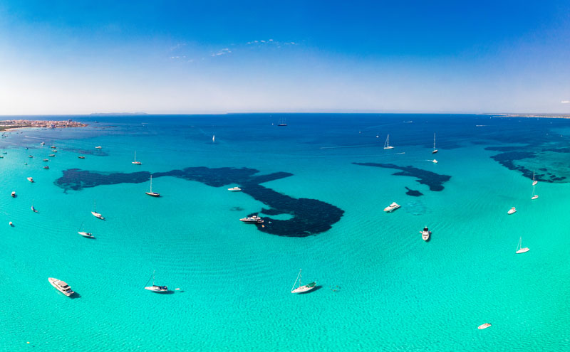 Das türkisblaue Meer der Balearen lädt zu Snorcheln oder Schwimmen ein. Die Balearen sind im Sommer ein beliebter Ort für Segelreisen. 